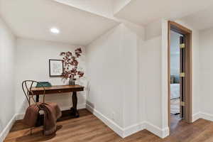 Living room with wood finished floors, baseboards, and recessed lighting