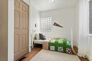 Bedroom featuring wood finished floors and baseboards