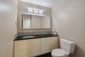 Half bathroom featuring toilet and vanity