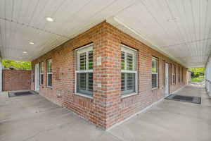 View of side of property featuring brick siding and covered porch