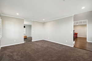 Unfurnished room featuring ornamental molding, baseboards, recessed lighting, and dark colored carpet