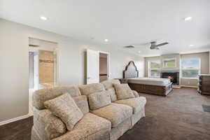 Bedroom featuring carpet, recessed lighting, baseboards, a glass covered fireplace, and a ceiling fan