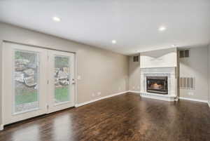 Unfurnished living room featuring a fireplace, wood finished floors, baseboards, and recessed lighting