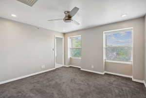 Spare room with a ceiling fan, dark carpet, baseboards, and recessed lighting