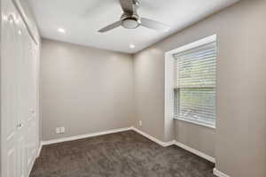 Spare room featuring a ceiling fan, dark colored carpet, baseboards, and recessed lighting