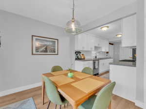 Dining space with light wood-style flooring and baseboards