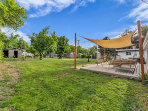 View of yard featuring a shed, an outbuilding, and a deck