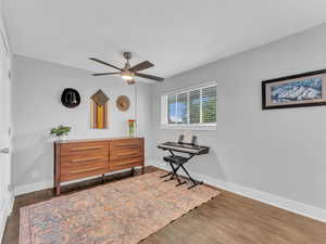 Bedroom featuring baseboards, wood finished floors, and ceiling fan