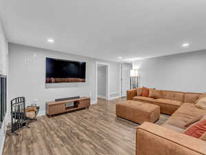 Living area with wood finished floors, recessed lighting, and baseboards