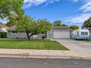 Obstructed view of property featuring a front lawn, driveway, an attached garage, a shingled roof, and central air condition unit