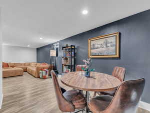 Dining room with light wood-style flooring, recessed lighting, and baseboards