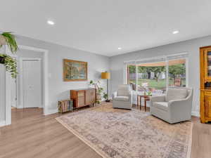 Living area with recessed lighting, baseboards, and light wood-style floors