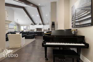 Miscellaneous room featuring beam ceiling, a fireplace, dark wood-type flooring, high vaulted ceiling, and recessed lighting