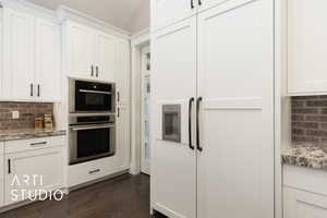 Kitchen featuring tasteful backsplash, dark wood-type flooring, white cabinetry, and vaulted ceiling