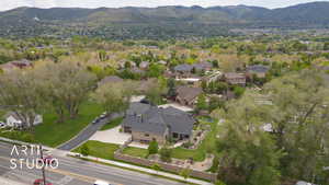 Aerial view of property and surrounding area featuring a mountain backdrop and nearby suburban area