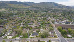 Aerial view of property and surrounding area with mountains and nearby suburban area