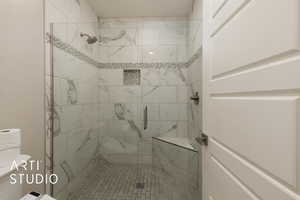 Full bathroom with a stall shower and toilet
