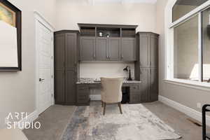 Office space with built in study area, carpet flooring, and baseboards