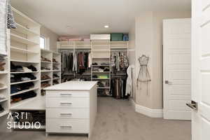 Walk in closet with light colored carpet