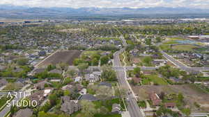 Aerial view of property and surrounding area featuring mountains and nearby suburban area