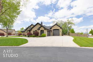 French provincial home featuring a garage, driveway, and stone siding