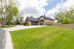 View of front facade with stone siding, a gate, concrete driveway, and an attached garage