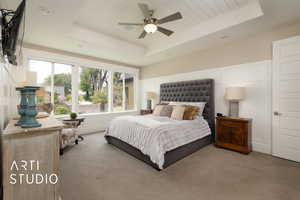 Carpeted bedroom with a raised ceiling and recessed lighting