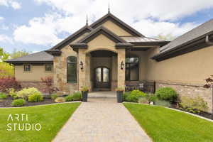 View of front of property with stucco siding, french doors, and a front yard