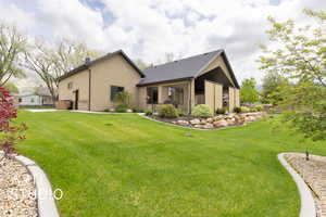 Rear view of property featuring a yard and stucco siding