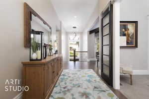Hall with baseboards, wood finished floors, and an upstairs landing