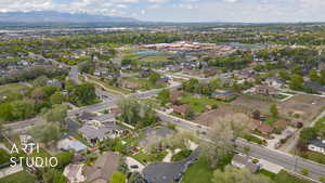 Aerial view of property and surrounding area featuring nearby suburban area and a mountain backdrop