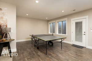 Rec room featuring wood finished floors, baseboards, and recessed lighting