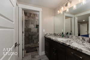 Full bathroom with vanity, tiled shower, and toilet