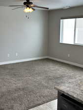 Unfurnished room with a textured ceiling, ceiling fan, carpet, and baseboards