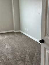 Spare room featuring baseboards and carpet flooring