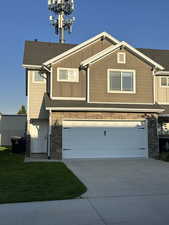 Craftsman house with stone siding, an attached garage, driveway, and board and batten siding