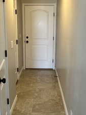 Doorway to outside featuring baseboards
