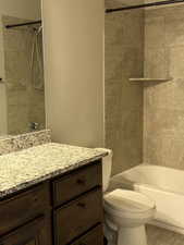 Bathroom with vanity, toilet, shower / tub combination, and tile patterned floors