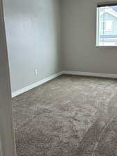 Carpeted empty room featuring baseboards