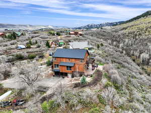 Aerial view of property and surrounding area with a mountain backdrop