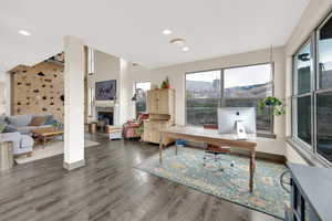 Office featuring a fireplace, wood finished floors, baseboards, and recessed lighting