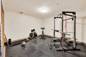 Exercise area featuring wood ceiling and baseboards