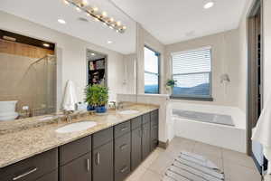 Bathroom with a stall shower, tile patterned floors, double vanity, recessed lighting, and toilet