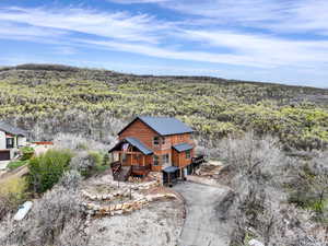 Aerial view of property and surrounding area featuring a forest