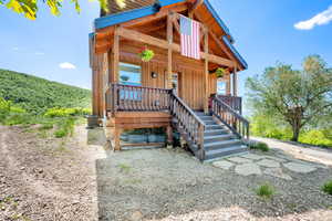 View of front facade featuring central AC, a porch, board and batten siding, and stairway