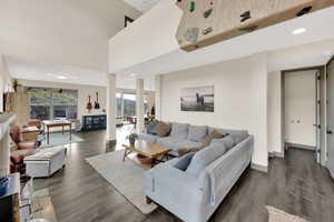 Living area featuring dark wood-style floors, recessed lighting, and baseboards