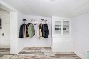 Walk in closet featuring lofted ceiling and light wood-type flooring