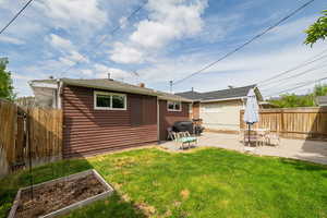 Back of property with a patio area, a vegetable garden, and a chimney