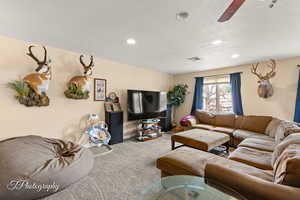 Living room featuring carpet floors, recessed lighting, ceiling fan, and baseboards