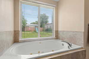 Bathroom featuring plenty of natural light and a tub with jets
